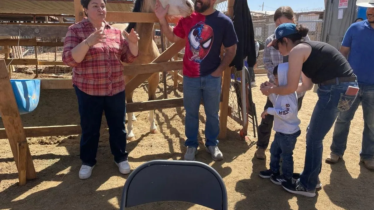 Una familia en una salida de ETP a una granja, junto a un caballo
